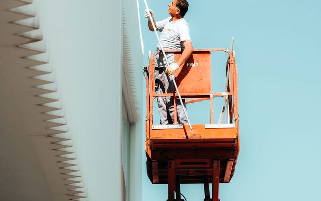 Peintre en nacelle sur un mur extérieur