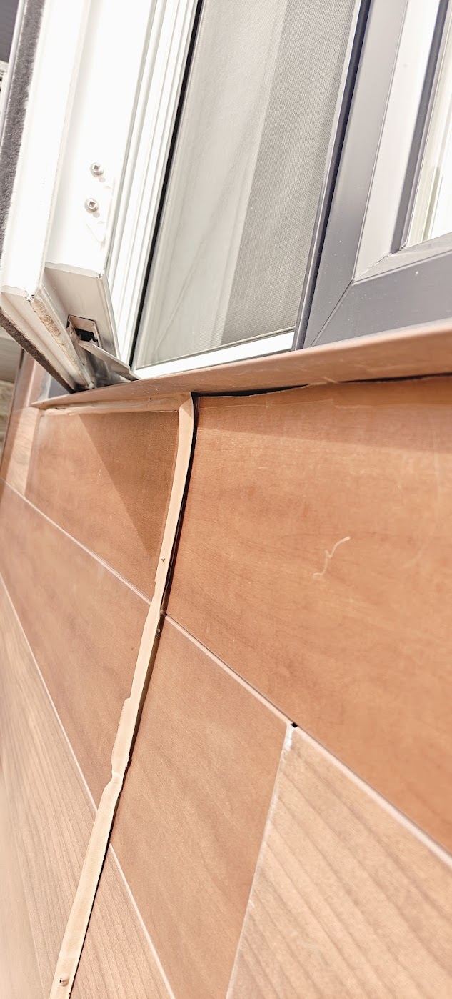 Photo de chantier : Joint décollé sous une fenêtre, à la jonction du revêtement